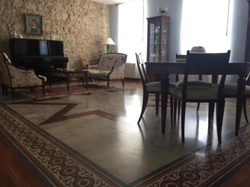 un soggiorno con tavolo, sedie e pianoforte di Campo Reale country rooms a Pachino