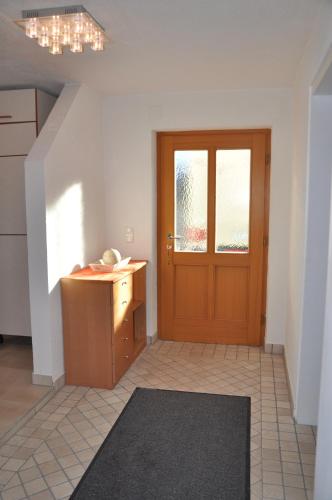ein leeres Zimmer mit einer Holztür und einem Schreibtisch in der Unterkunft Familien Appartement „Im Landhaus“ in Gaal