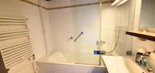 La salle de bains est pourvue d'une douche, d'une baignoire et d'un lavabo. dans l'établissement EV55, à Genève