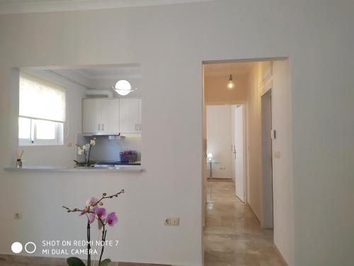 kuchnia z białymi szafkami i korytarzem w obiekcie Nafplio City Apartments w Nauplionie