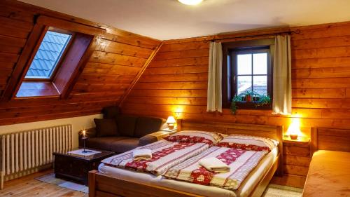 a bedroom with a bed and a couch and windows at Penzion Barborka in Poprad