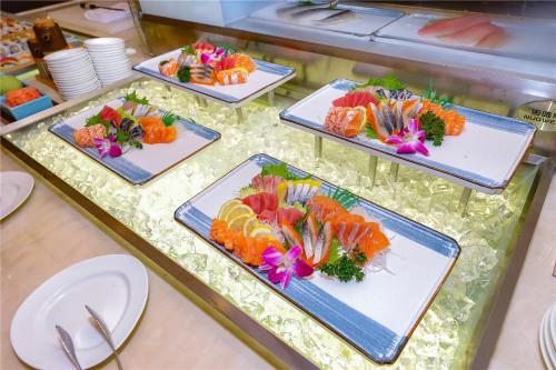 four plates of food on a buffet table at Millennium Harbourview Hotel Xiamen-Near Metro Station & Zhongshan Road in Xiamen