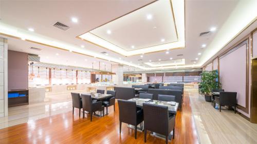 a restaurant with black chairs and tables in a room at Millennium Harbourview Hotel Xiamen-Near Metro Station & Zhongshan Road in Xiamen