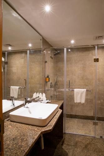 a bathroom with two sinks and a shower at Regenta Central Cassia Zirakpur Chandigarh in Chandīgarh