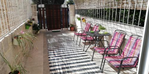 a patio with pink chairs and a table and a fence at IBIS Your Cosy Oasis With Private Parking and Patio in Split