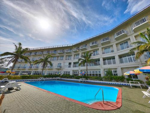 a hotel with a swimming pool in front of a building at Miyuki Hamabaru Resort in Onna