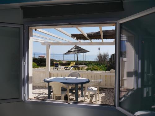 un patio avec une table et des chaises et une vue sur l'océan dans l'établissement Ô Bord de Mer !, à Hyères