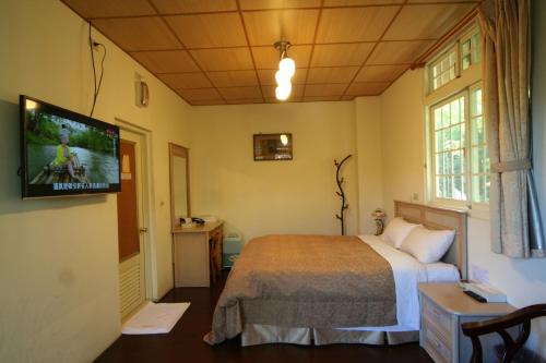 um quarto com uma cama e uma televisão de ecrã plano em Cing Jing Homeland Resort Villa em Ren'ai