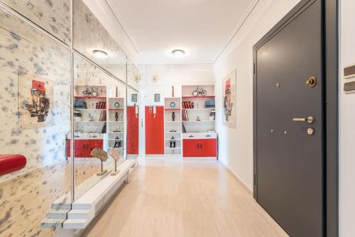 a hallway with red and white walls and a black door at Seaside Central Apartment in Athens