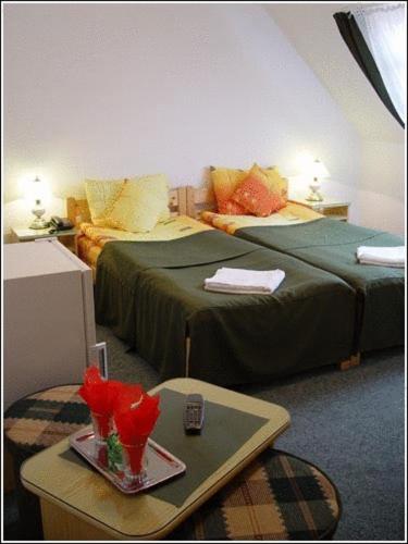 a hotel room with two beds and a table with flowers at Vila Casa Alesiv in Cluj-Napoca
