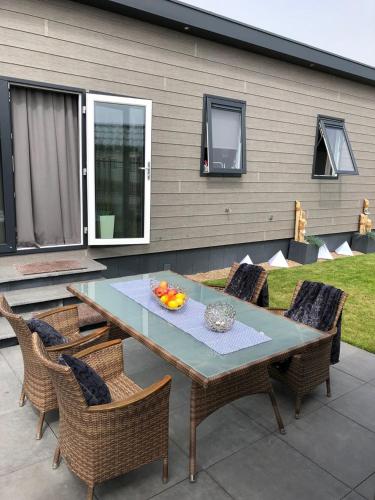 einen Tisch und Stühle mit einer Obstschale auf der Terrasse in der Unterkunft Chalet SOL Y MAR in Renesse