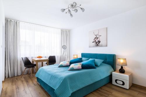 - une chambre avec un lit bleu et un bureau dans l'établissement Apartament Stag Karkonosz - 2 osobne pokoje - by Space Apart, à Jelenia Góra