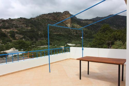 a table on a balcony with a view of a mountain at Aaron Studios Apartments in Agia Fotia