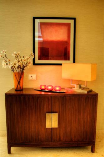 a table with a lamp and a picture on a wall at 76 Friends Colony in New Delhi