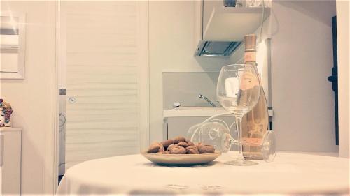 陶爾米納的住宿－Casa Cleone，一张桌子,上面放着一碗坚果和一杯葡萄酒