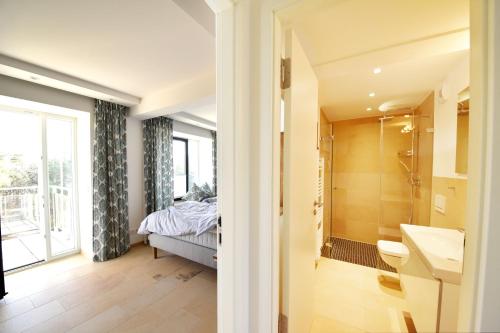 a bathroom with a sink and a shower and a bed at Ferienwohnung "Solopgang" im Haus Granitz in Binz