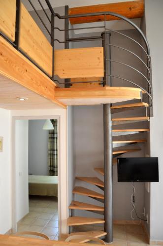 Cette chambre comprend une mezzanine avec un escalier en colimaçon. dans l'établissement Résidence Vacances Fontenelle, à Raphèle