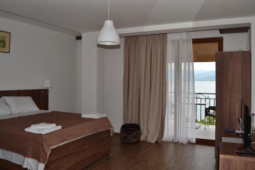 Schlafzimmer mit einem Bett und Meerblick in der Unterkunft Hotel La Terrazza in Star Dojran