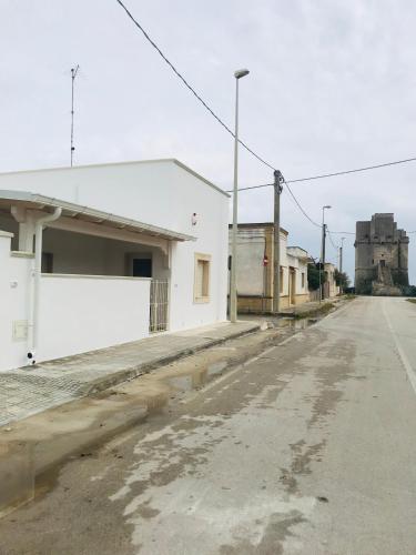 an empty street next to a white building at Villetta Natalia 2 in Torre Colimena