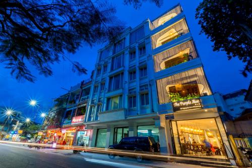 a tall blue building on a city street at night at Purple Hue Central Hub in Hue