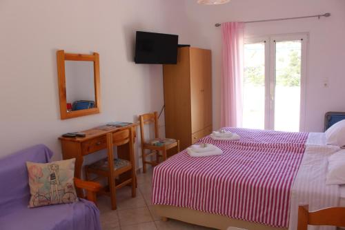 a bedroom with a bed and a desk and a mirror at Aaron Studios Apartments in Agia Fotia
