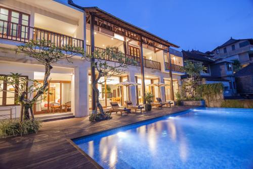 a swimming pool in front of a house at River Sakti Ubud by Prasi in Ubud
