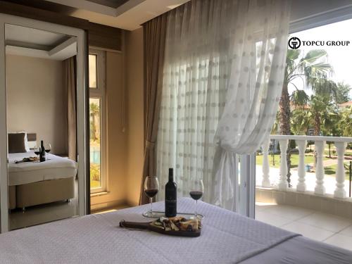 1 dormitorio con mesa y 2 copas de vino en Belek Golf Village - Villa with shared pool, en Belek