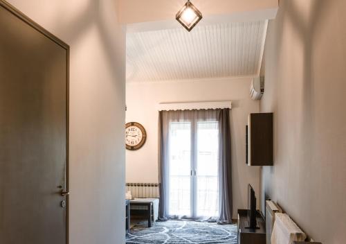 a hallway with a window and a clock on the ceiling at Andria City Apartment in Zakynthos