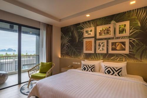 a bedroom with a bed and a large window at Panan Krabi Resort in Ao Nang Beach