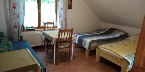 Zimmer mit 2 Betten, einem Tisch und Stühlen in der Unterkunft Dobogókő vendégház in Dobogókő