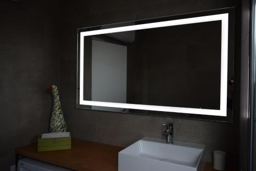 a bathroom with a sink and a large mirror at Villa Alcova in Caorle