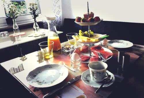 un tavolo con piatti di cibo e un vassoio di frutta di GÄSTEHAUS LIFESTYLE a Kirrweiler