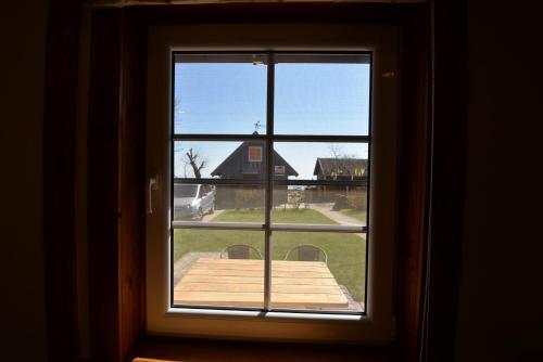 an open window with a view of a house at Preiloje pas Žilviną in Neringa