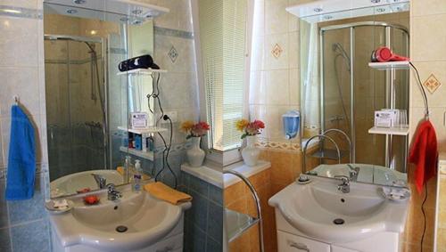 a bathroom with two sinks and a shower at Kenézy Lux Apartman Vendégház in Hajdúszoboszló