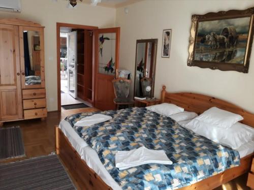 a bedroom with a large bed with towels on it at Kenézy Lux Apartman Vendégház in Hajdúszoboszló