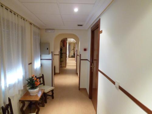 a corridor of a hallway with a table and chairs at Hostal Madrid in Toledo