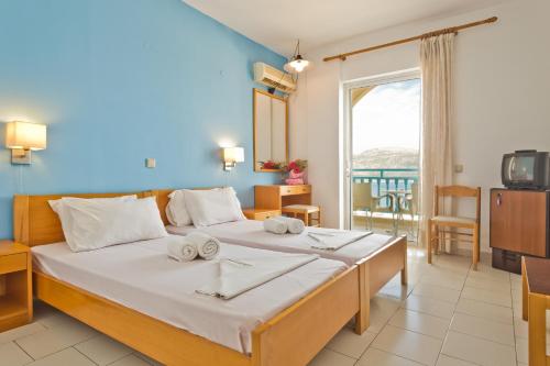een slaapkamer met een groot bed en handdoeken bij Olympic Hotel in Karpathos