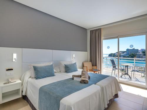 a hotel room with a large bed and a balcony at Son Matias Beach - Adults Only in Palmanova