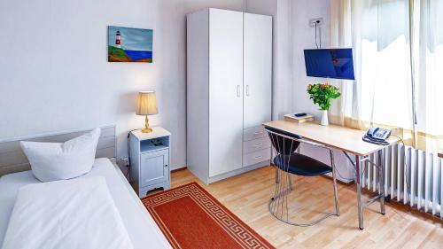 ein Schlafzimmer mit einem Schreibtisch, einem Bett und einem Tisch in der Unterkunft Hotel Cornelia in Bad Nauheim
