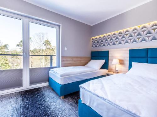 - une chambre avec 2 lits et une grande fenêtre dans l'établissement VacationClub – Cesarskie Ogrody Apartament 758, à Świnoujście
