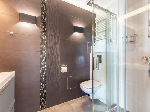 La salle de bains est pourvue de toilettes et d'une douche en verre. dans l'établissement VacationClub – Cesarskie Ogrody Apartament 758, à Świnoujście