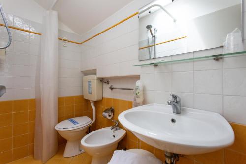 a bathroom with a sink and a toilet at Hotel Cimarosa in Riccione