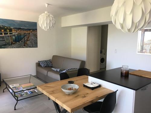 a living room with a table and a couch at Charmant T2 Hauteurs de Bastia in Bastia