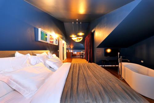 a bedroom with a large bed and a tub at Boutique Hotel Boškinac in Novalja