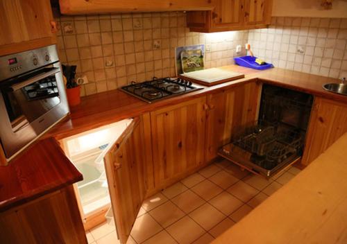 a kitchen with a stove and an open oven at Au Petit Gîte Les Paccots in Châtel-Saint-Denis