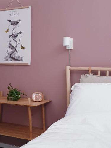 - une chambre avec un lit et une table avec une horloge dans l'établissement Appartement Plek in Holten, à Holten