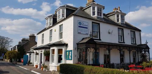 a white building with a sign in front of it at The Havelock in Nairn
