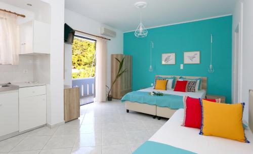 una camera con due letti e una parete blu di Yiannis Studios ad Agia Marina