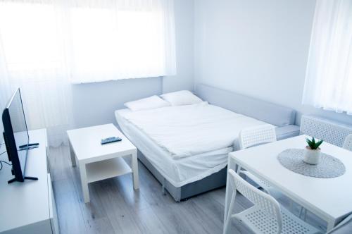 a small room with a bed and a table at Apartament Wiesio in Gdynia
