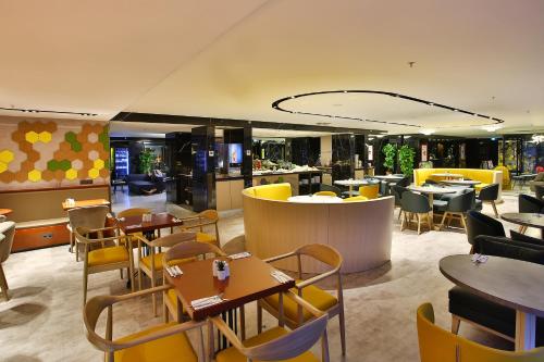 a restaurant with tables and chairs and a bar at ibis Styles Istanbul Bomonti in Istanbul